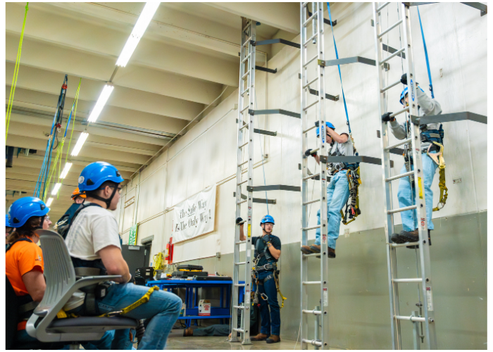 Wind energy students training on a wind turbine tower.