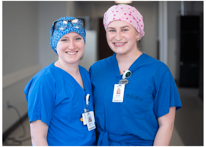 Two Lake Region State College allied health students wearing blue scrubs.