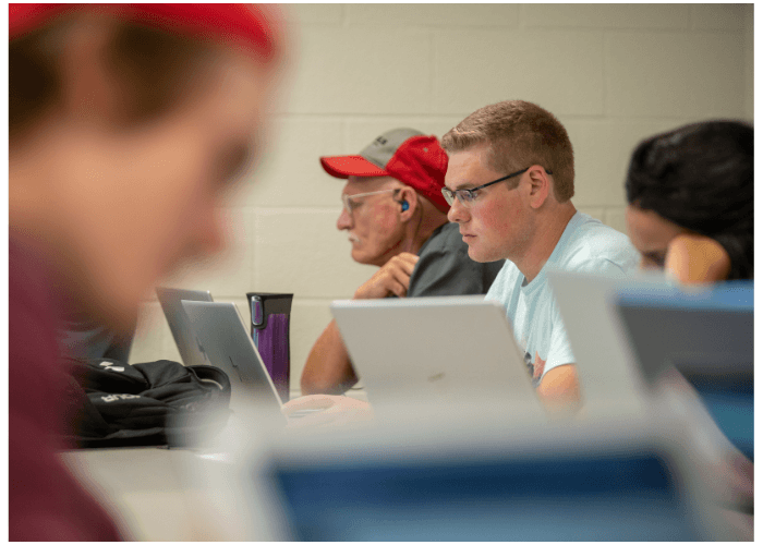Lake Region State College student works on a laptop computer in a classroom setting.
