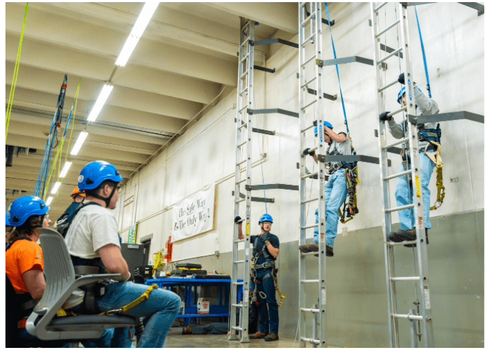Wind energy students training on a wind turbine tower.