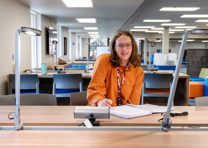 Female student in the library working on homework. 