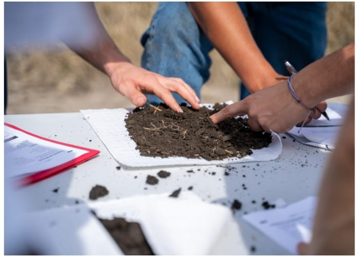 Students examining soil outside. 
