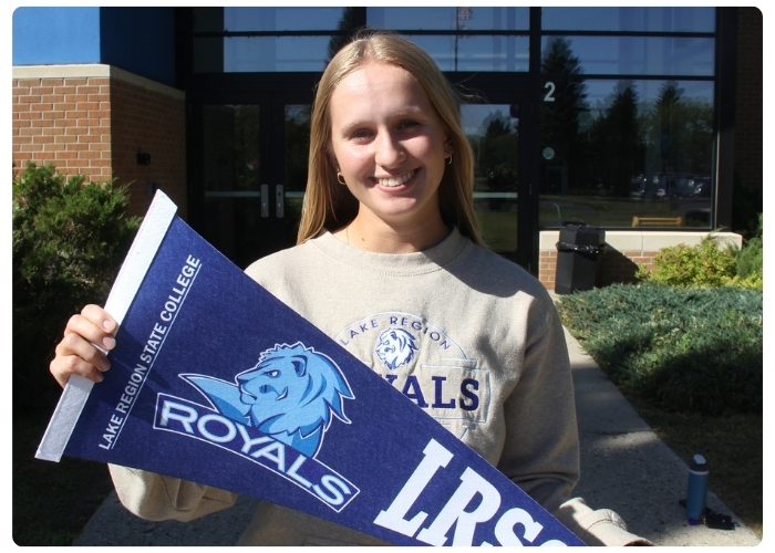 LRSC student holding a banner in front of the campus.