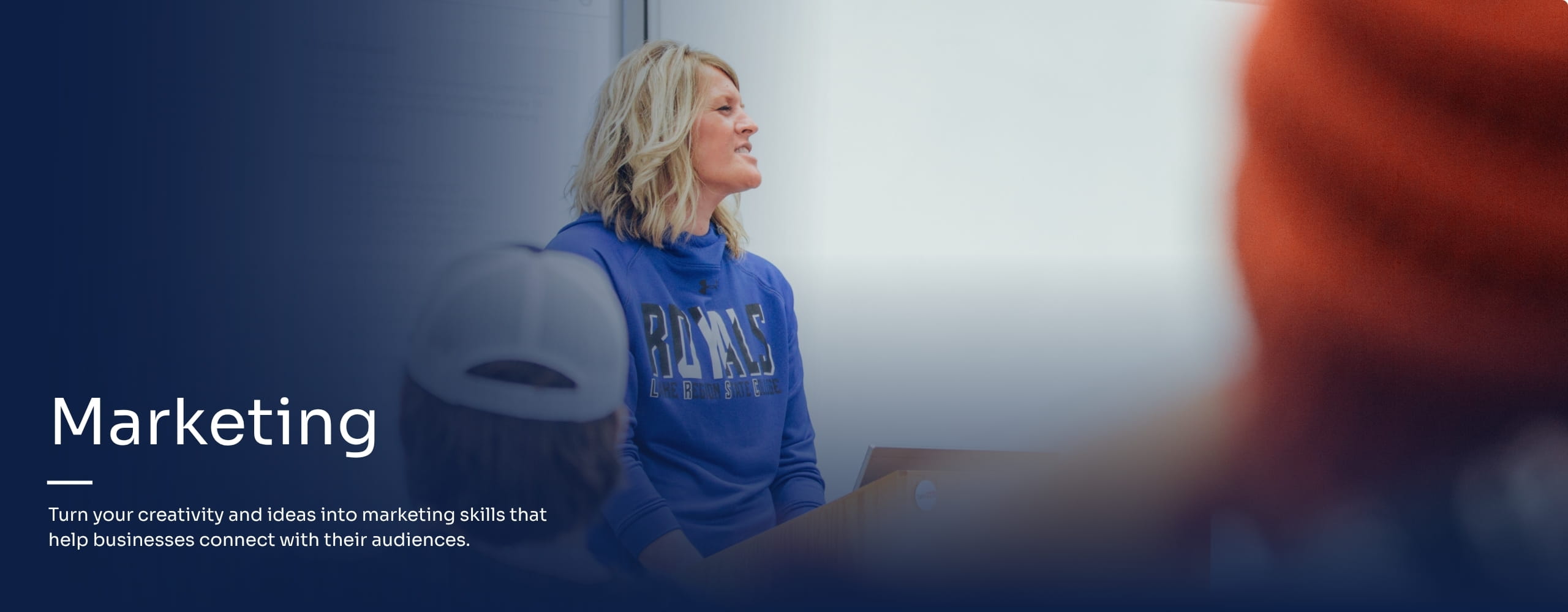 Marketing instructor lecturing in front of a class.