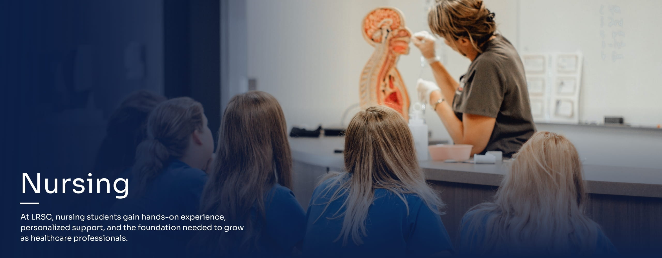 Nursing instructor teaching in front of a class.