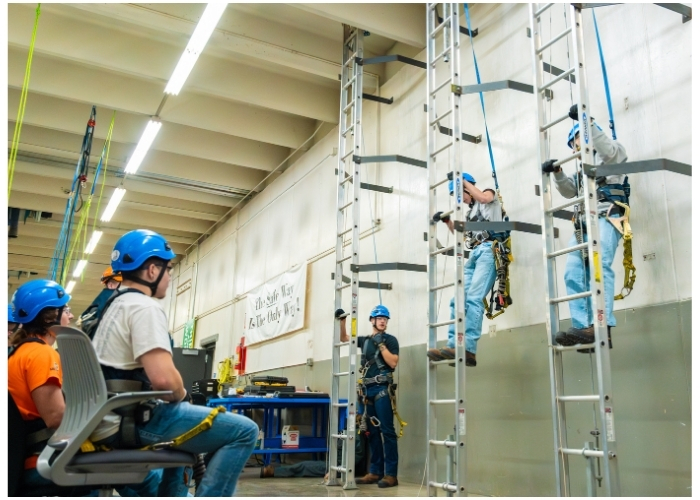 Wind energy students training on a wind turbine tower.