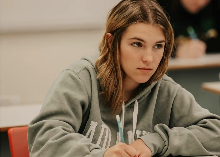 Student taking notes during a classroom lecture.