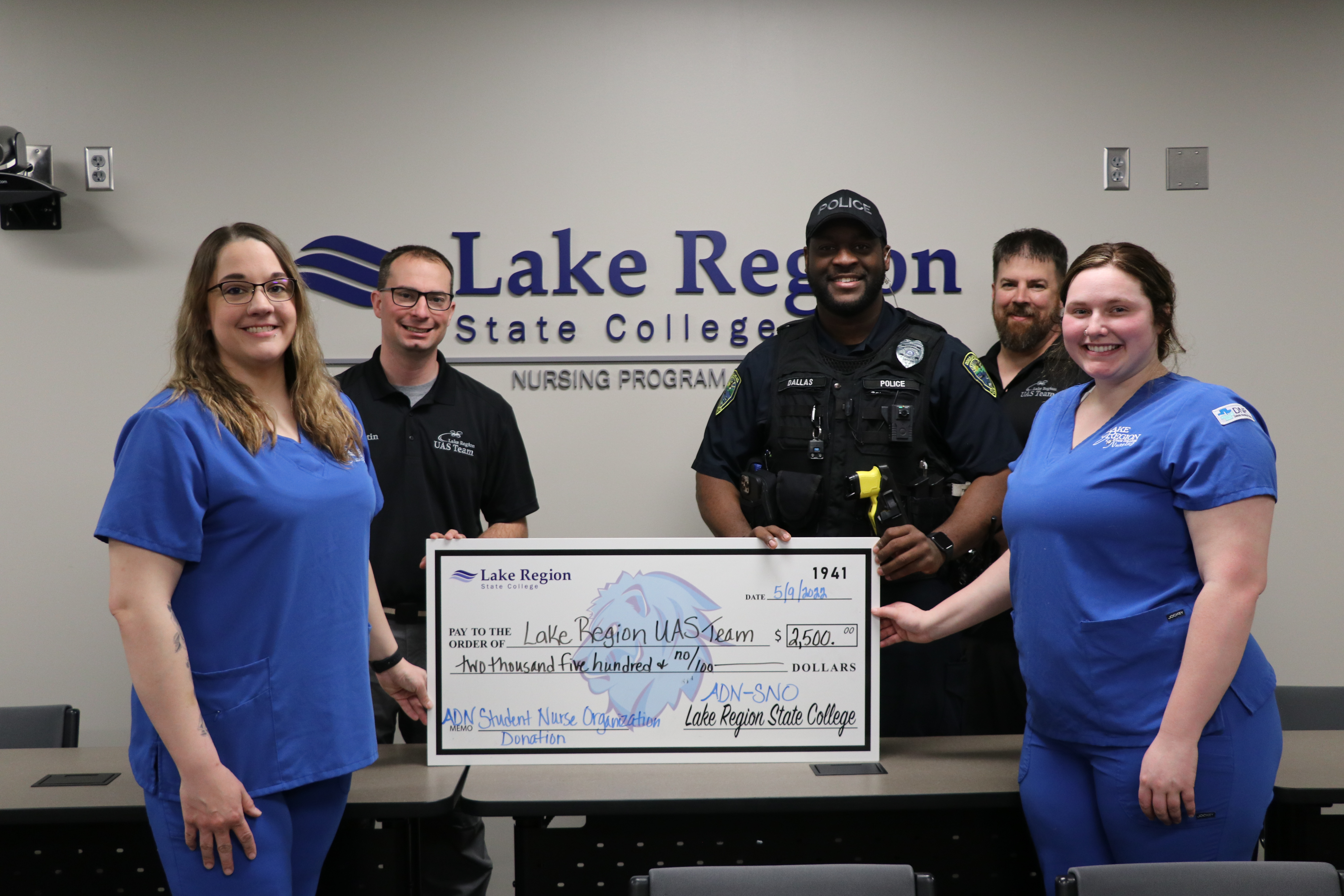 student nurses present check to uas team