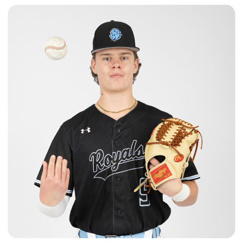 Student athlete wearing a black Lake Region State College Royals baseball uniform, holding a baseball glove while tossing a baseball in a studio setting against a light background.