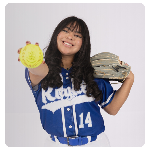 Student athlete wearing a blue Lake Region State College Royals softball uniform with the number 14, holding a softball forward and a glove over one shoulder against a light studio background.