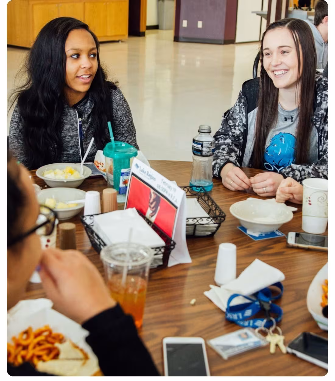 Students sit together at a table eating meals in the Lake Region State College dining room.
