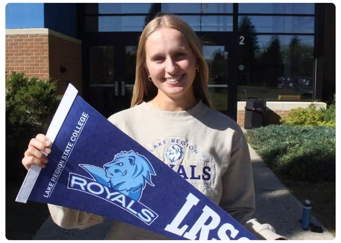 LRSC student holding a banner in front of the campus.
