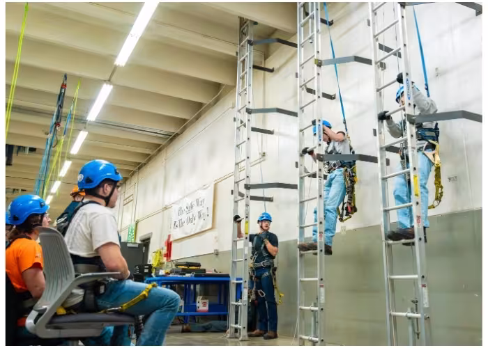 Wind energy students training on a wind turbine tower.