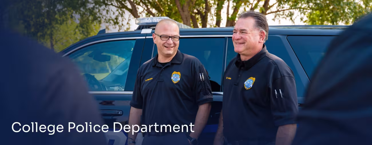 Campus police officers standing near a patrol vehicle.