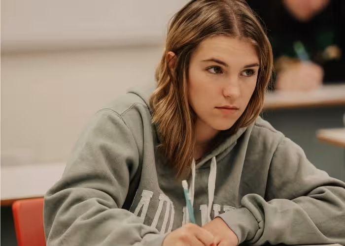 Student taking notes during a classroom lecture.