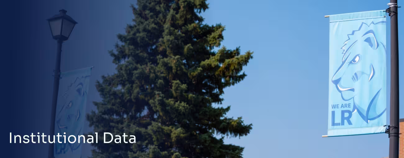 LRSC campus banner displayed beside a large evergreen tree.