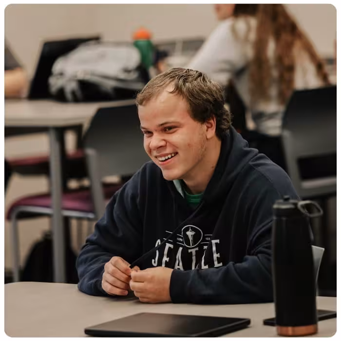Student smiling in a classroom.