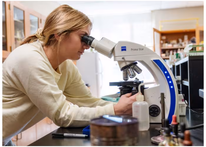 Student using a microscope in a science lab.