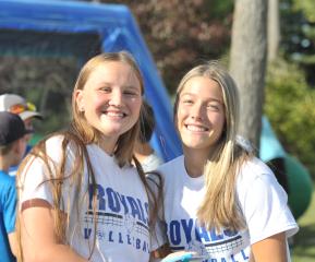 Two female co-eds pose at outdoor gathering at LRSC