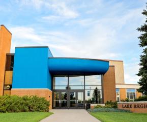 Lake Region State College campus building entrance with blue facade and brick college sign.