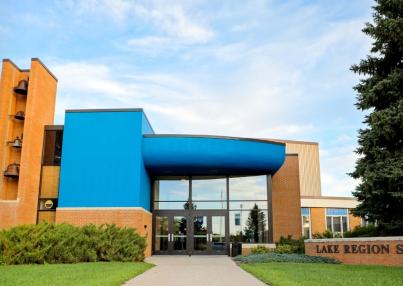 Lake Region State College campus building entrance with blue facade and brick college sign.