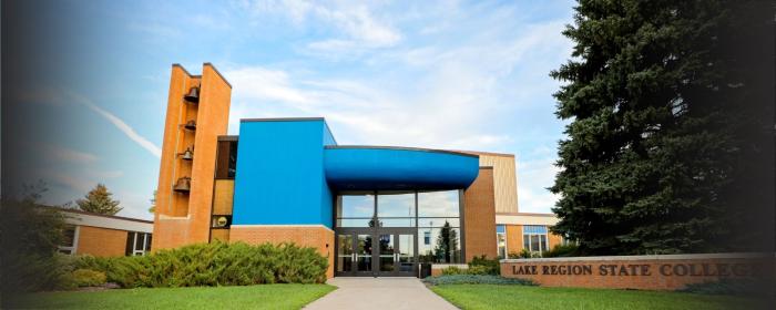 Lake Region State College campus building entrance with blue facade and brick college sign.